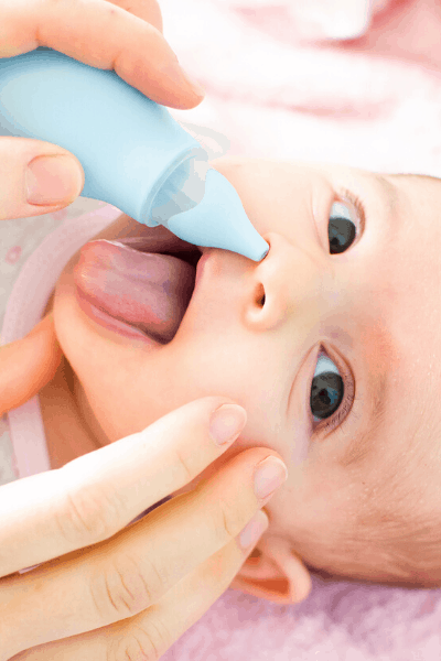 Cute baby with baby aspirator in nose