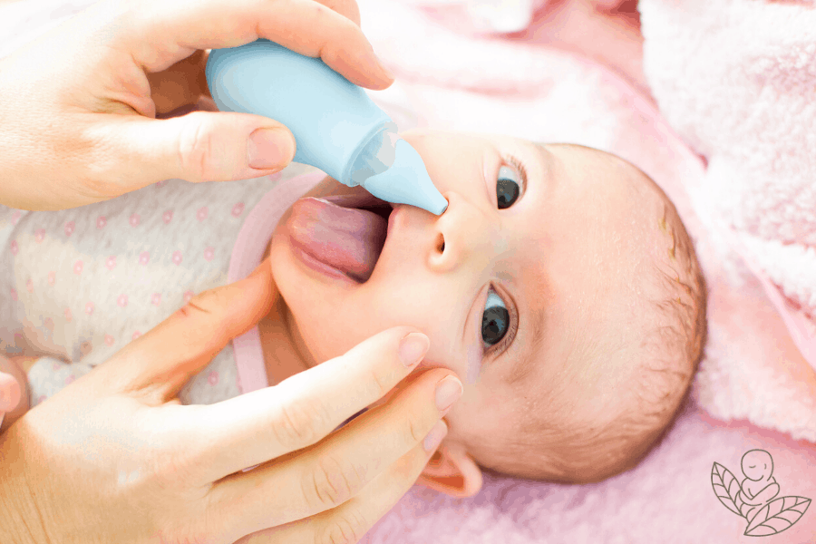 Cute baby with baby aspirator in nose