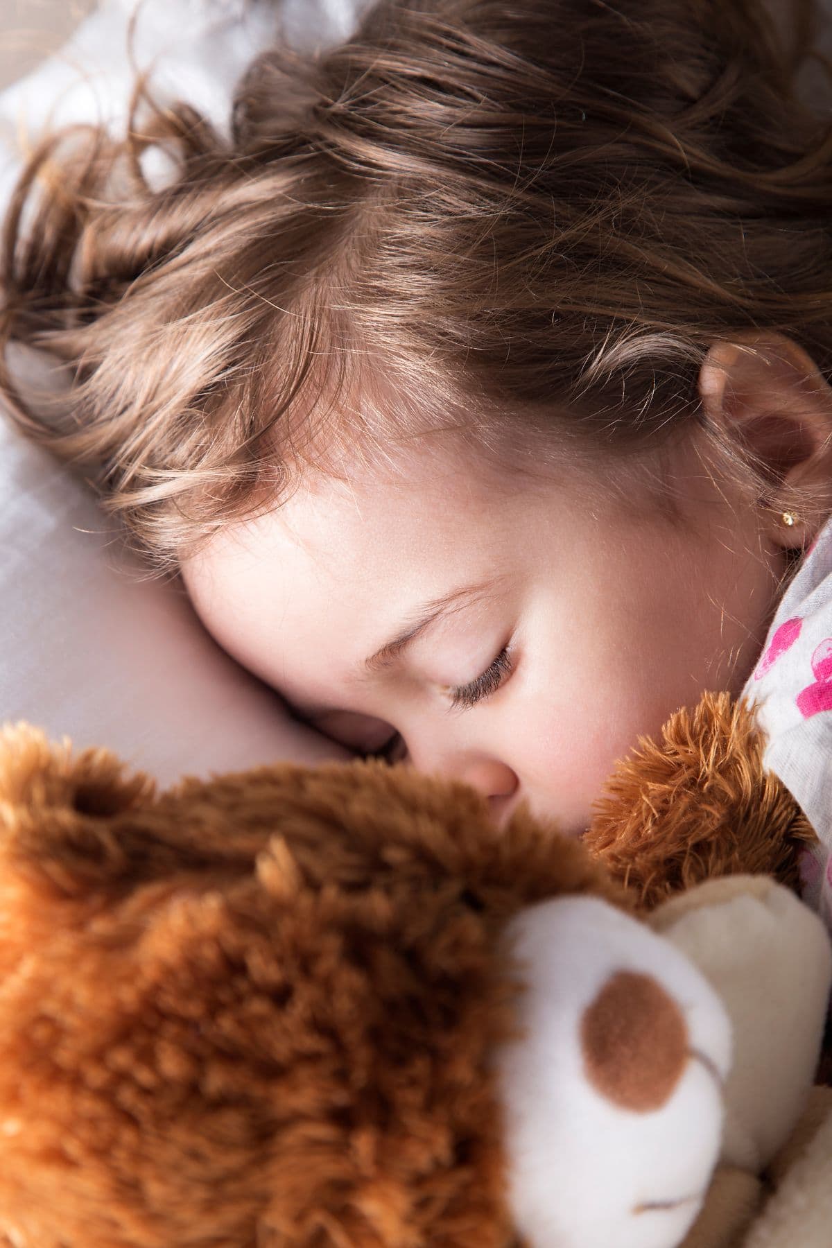 baby holding stuffed bear